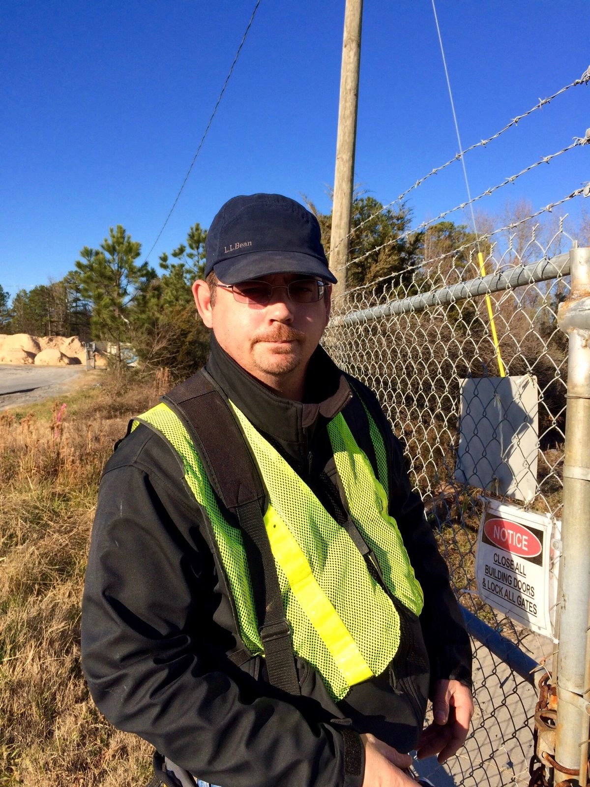Professional land surveyor in safety vest at construction site